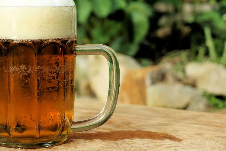 Chope de bière artisanale ambrée au col mousseux